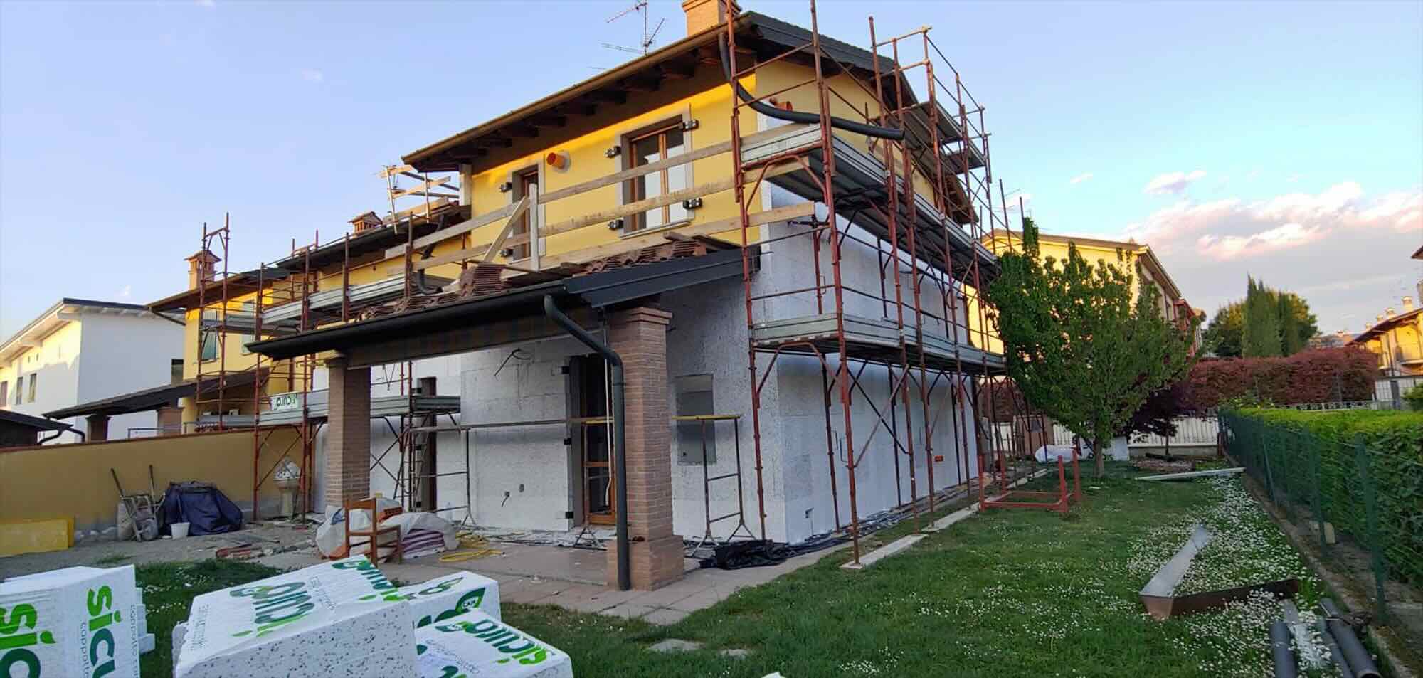 Casa in ristrutturazione con cappotto termico e ponteggi per riqualificazione edilizia